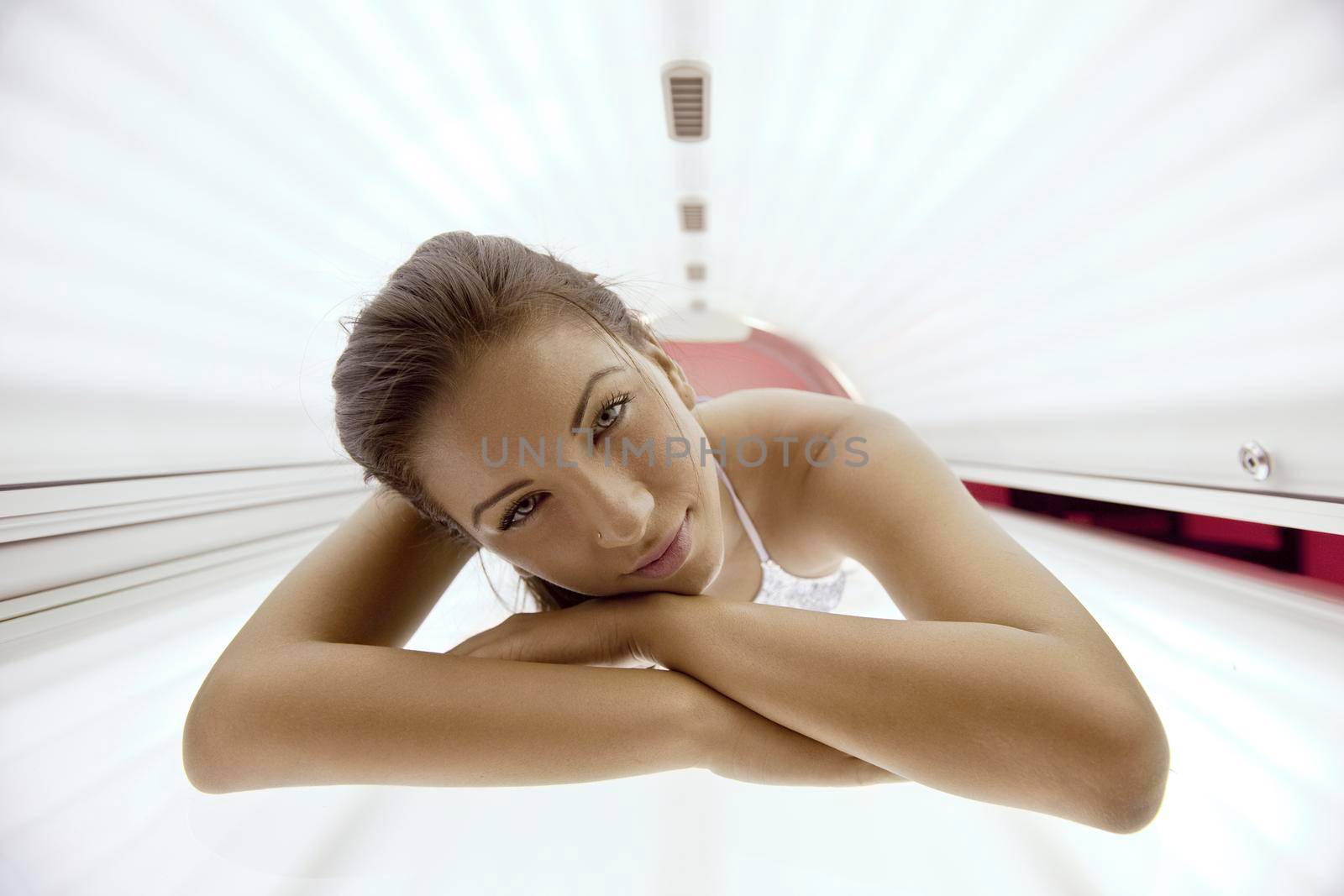 Beautiful young woman have tanning skin treatment in modern solarium