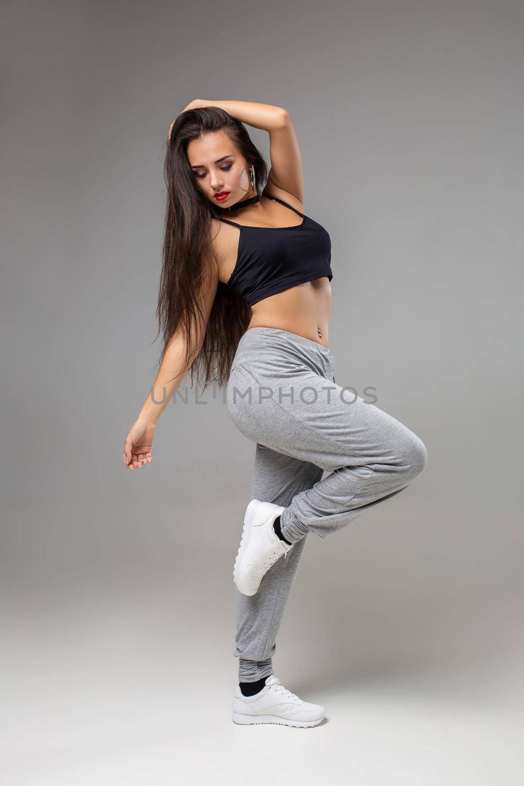 Modern style dancer posing on studio background. Dancing. Hobby. Hip hop, jazz funk, dancehall