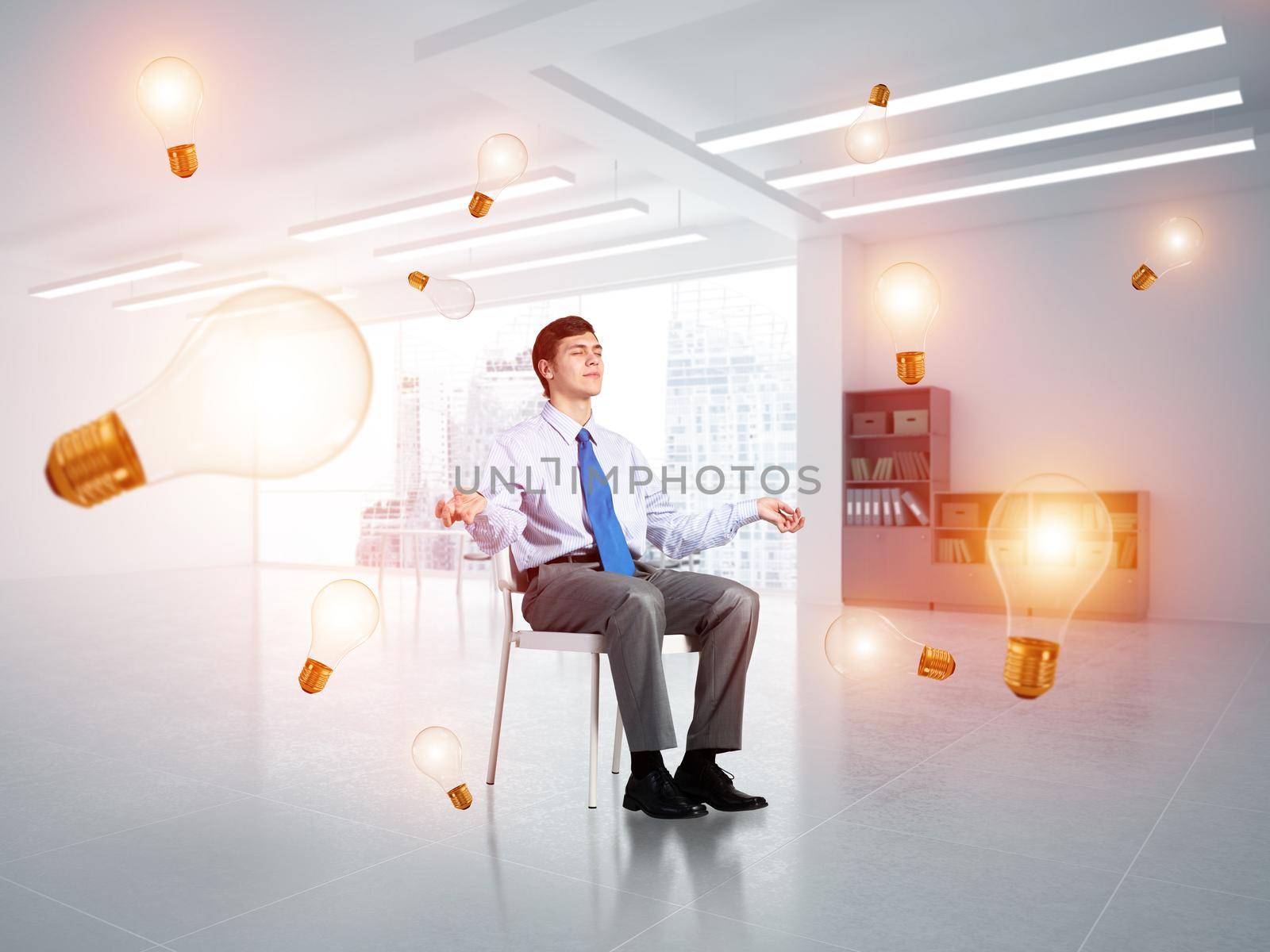young businessman in the office meditates. concept of creativity