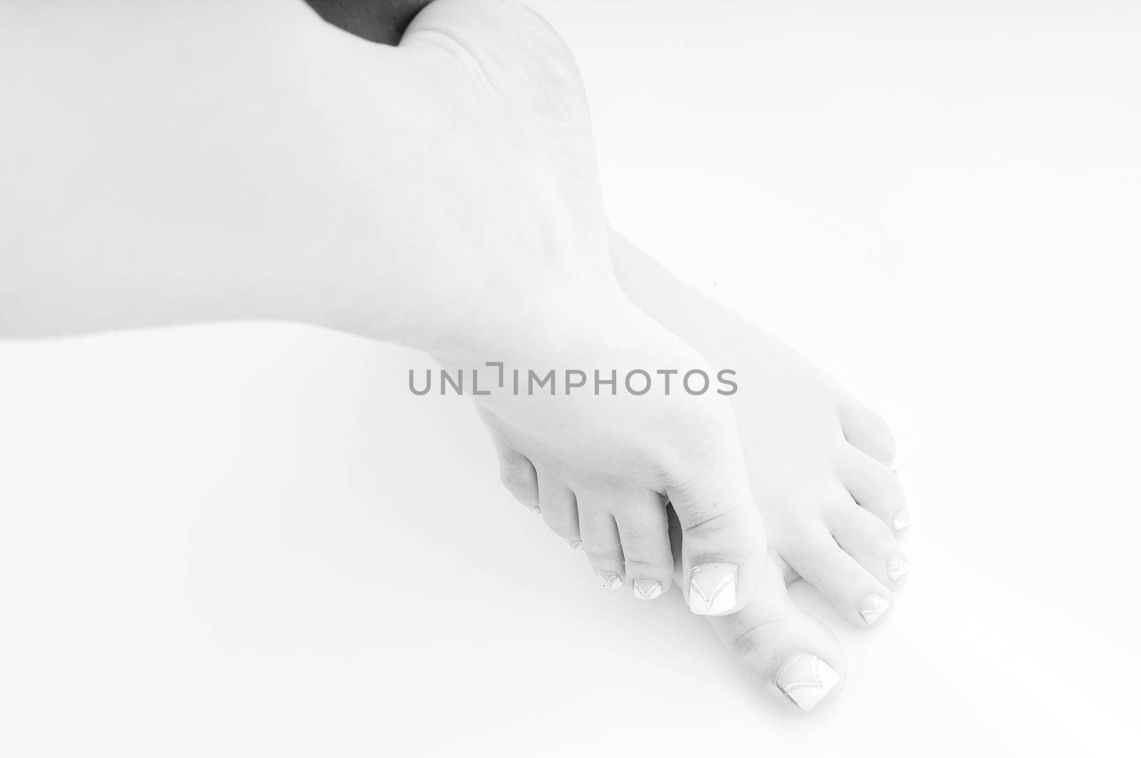 young woman bare foot with makeup nails islated on white