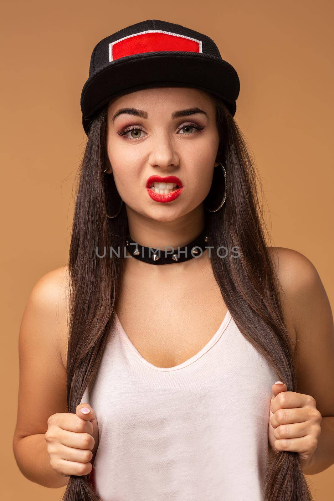 Close up positive portrait of pretty girl with amazing long brunette hair, bright sportive hat, bright make up, crazy funny face. Hip hop, jazz funk, dancehall