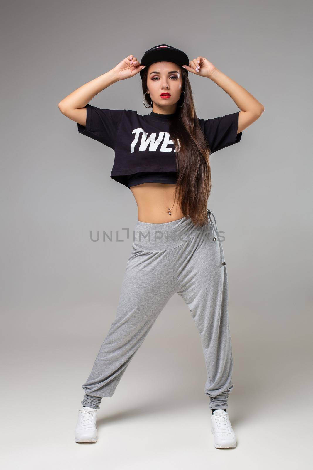 Modern style dancer posing on studio background. Dancing. Hobby. Hip hop, jazz funk, dancehall