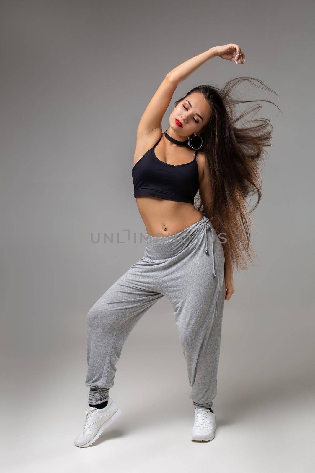 Modern style dancer posing on studio background. Dancing. Hobby. Hip hop, jazz funk, dancehall