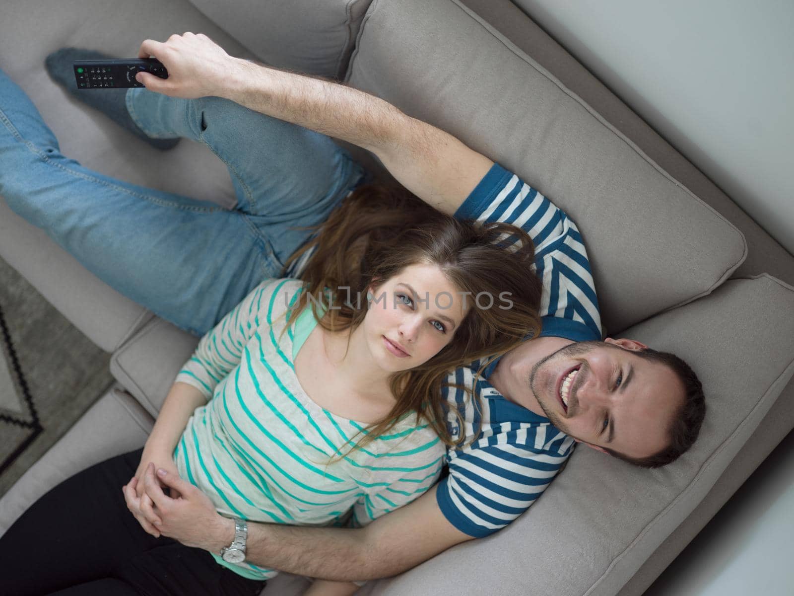 young handsome couple enjoys hugging on the sofa in their luxury home villa