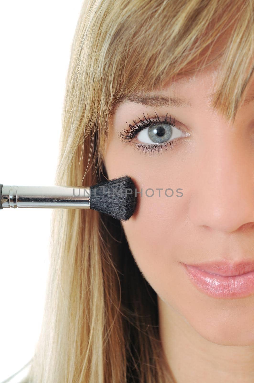 beautiful young woman apply powder makeup with brush isolated on white