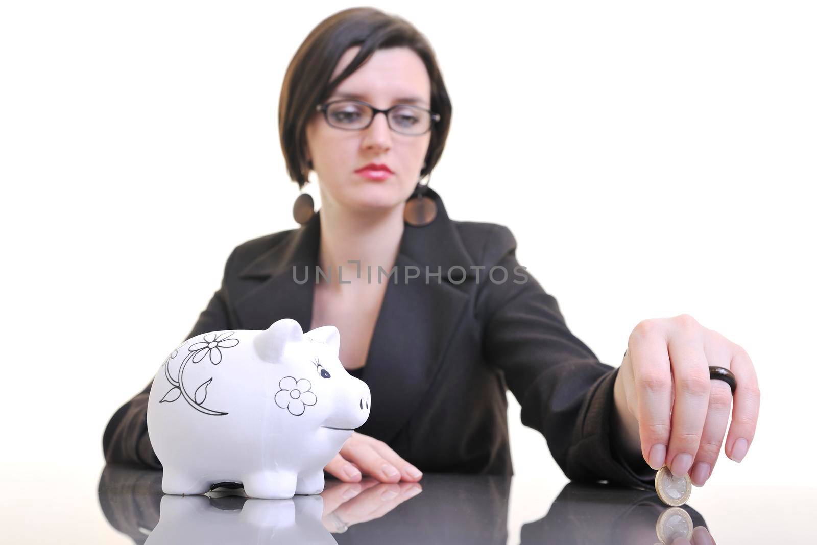 young business woman iosolated on white putting coins money in piggy bank and representing concept of saving and smart spending money