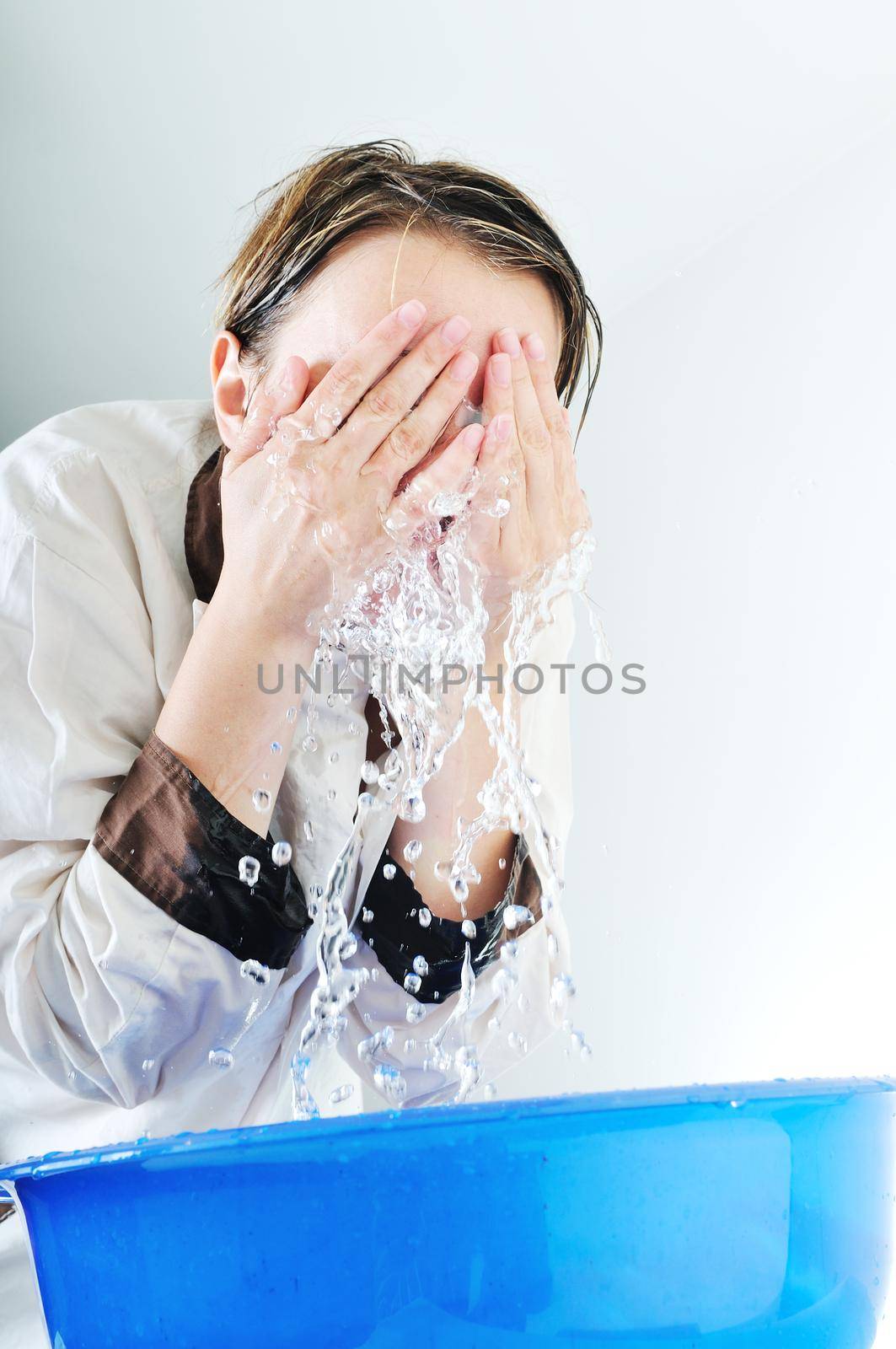bautiful young woman wash face with clean water isolated on white in studio