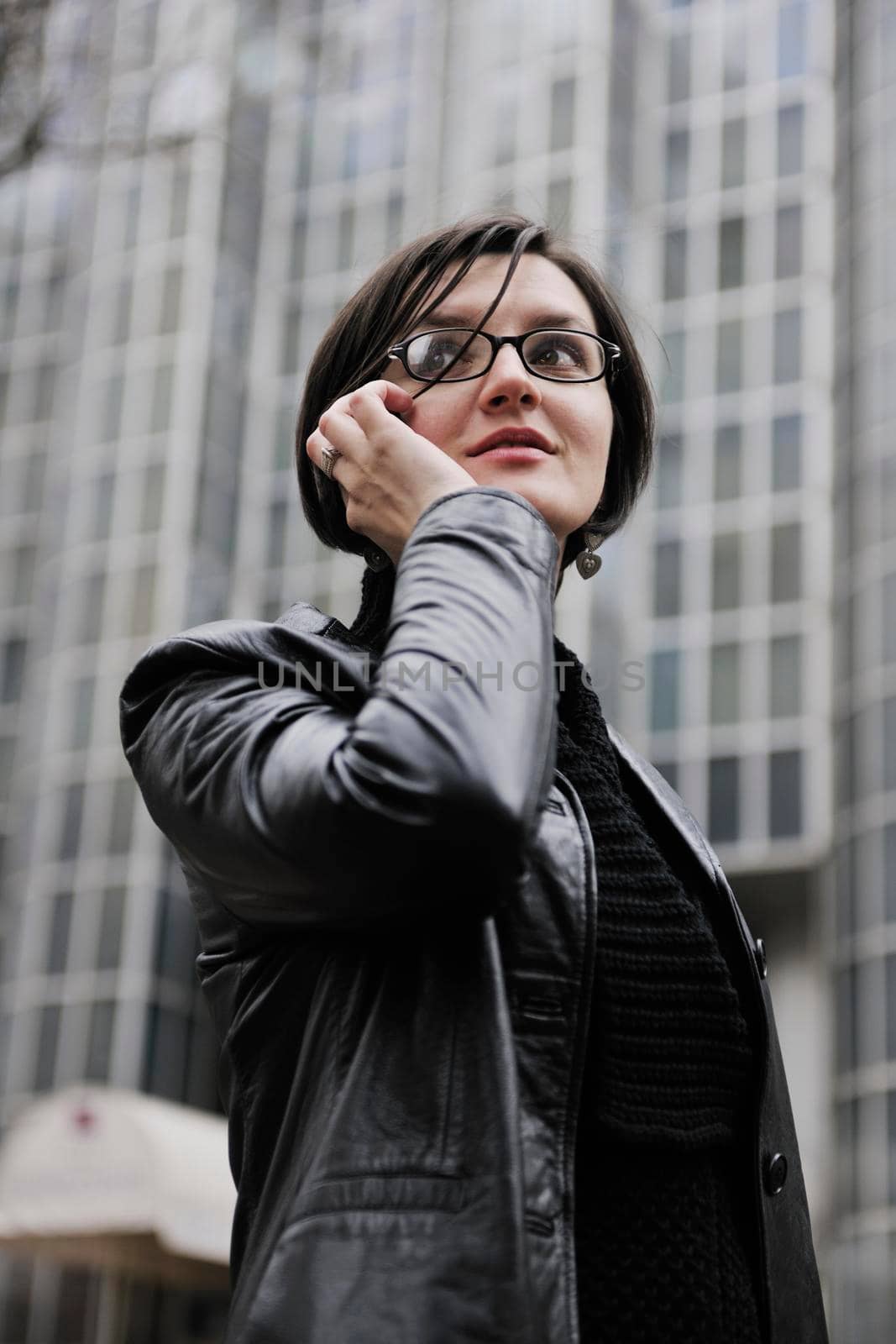 young business woman talking by phone on street