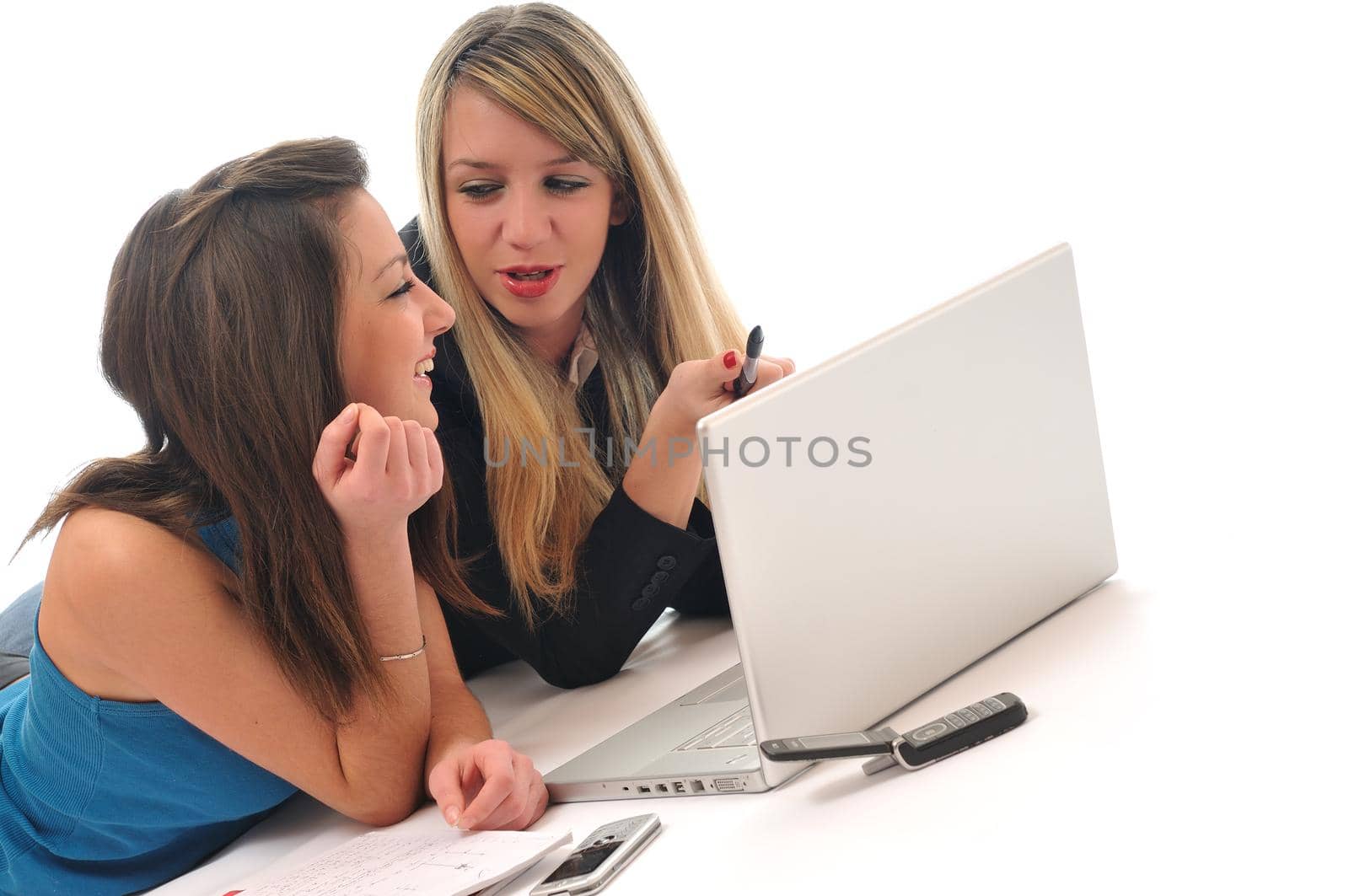 two young girls work on laptop isolated by dotshock