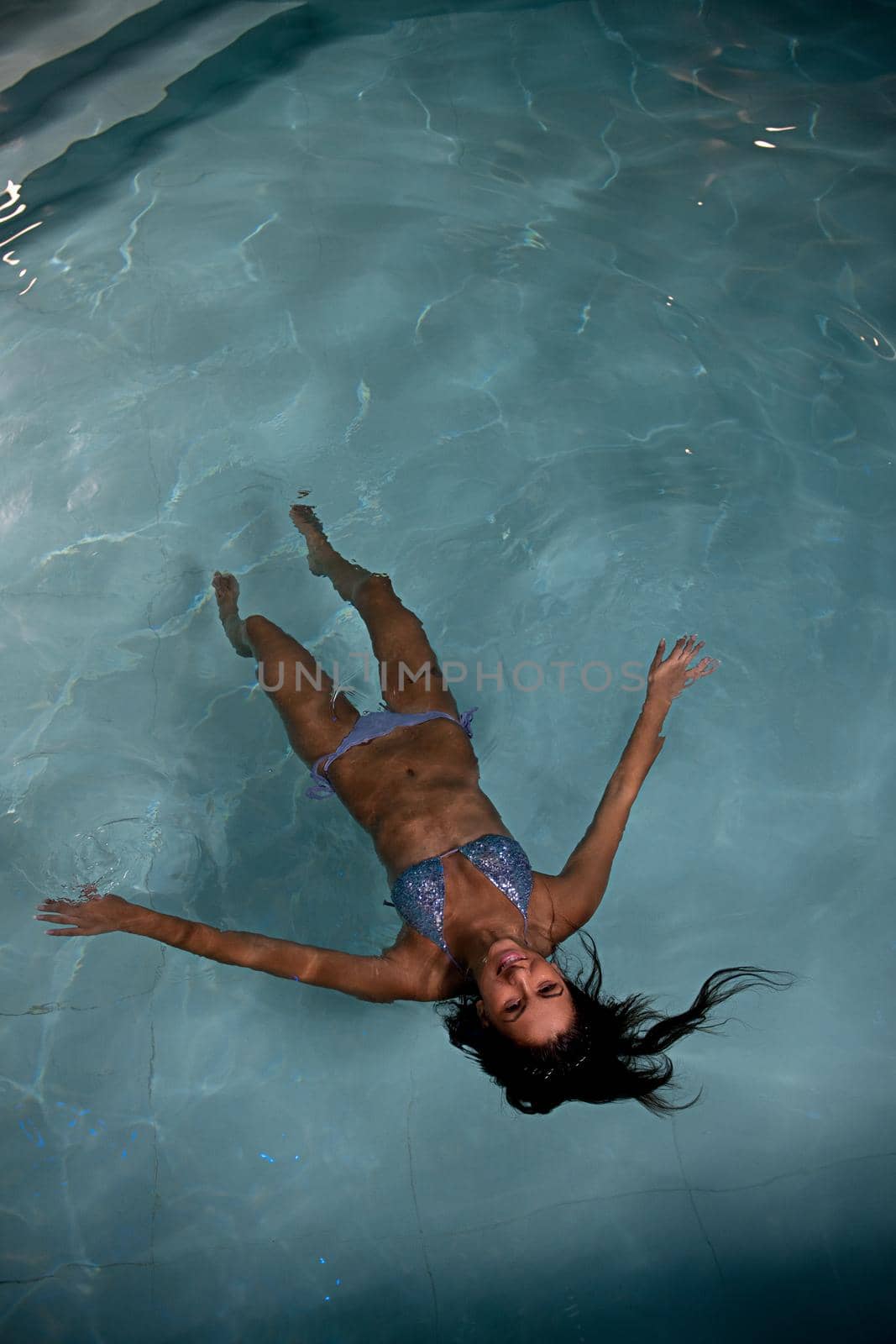 Closeup of pretty young lady have fun and posing  while relaxing in the swimming pool in luxury hotel