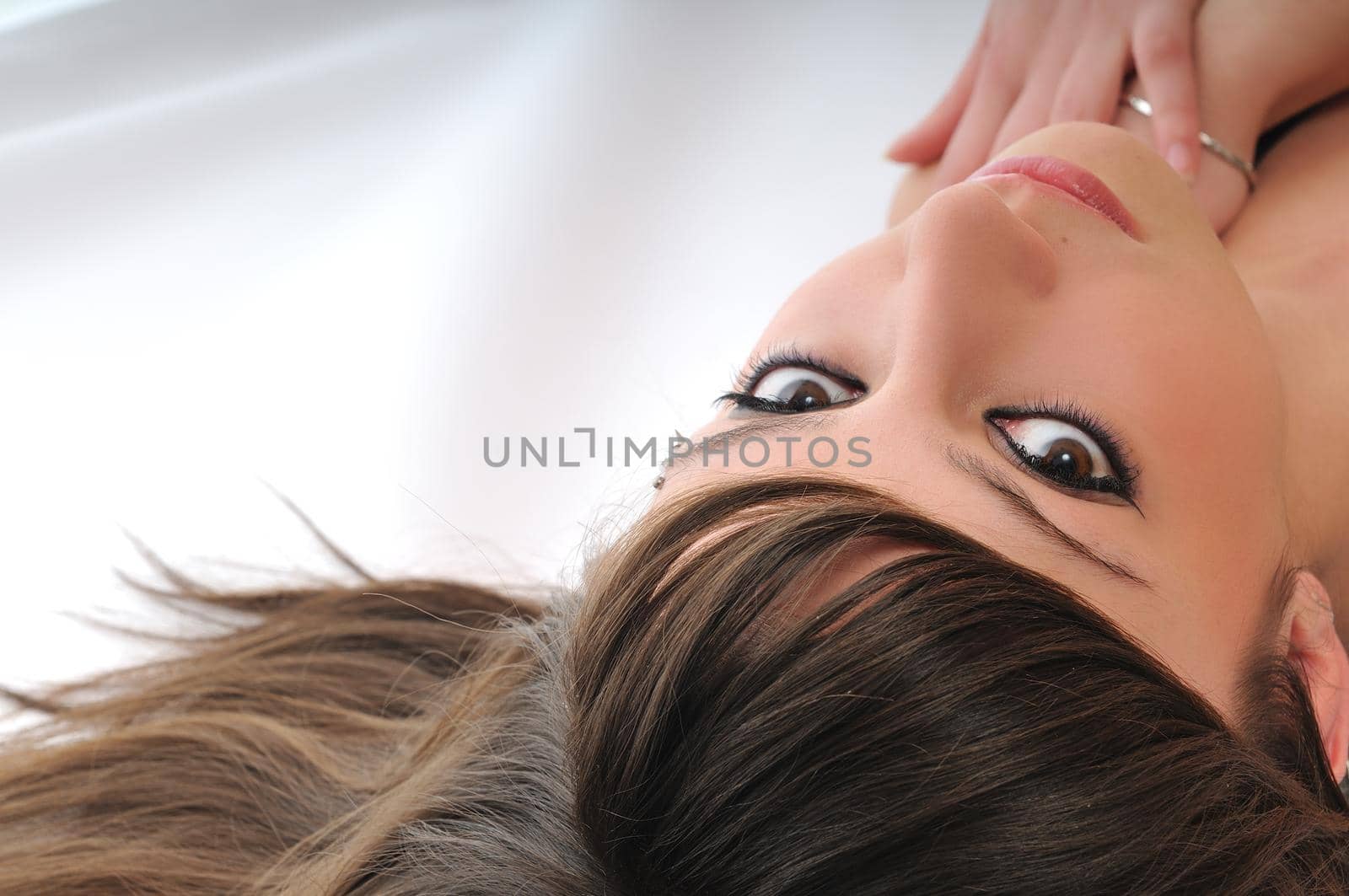 young woman with beautiful face lie on floor isolated closeup