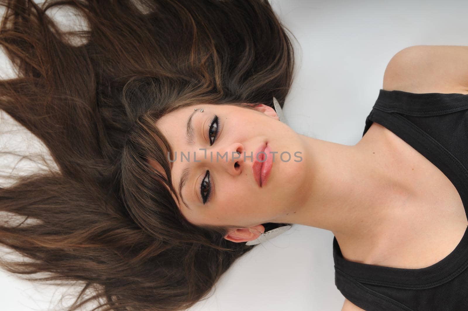 young woman with beautiful face lie on floor isolated closeup