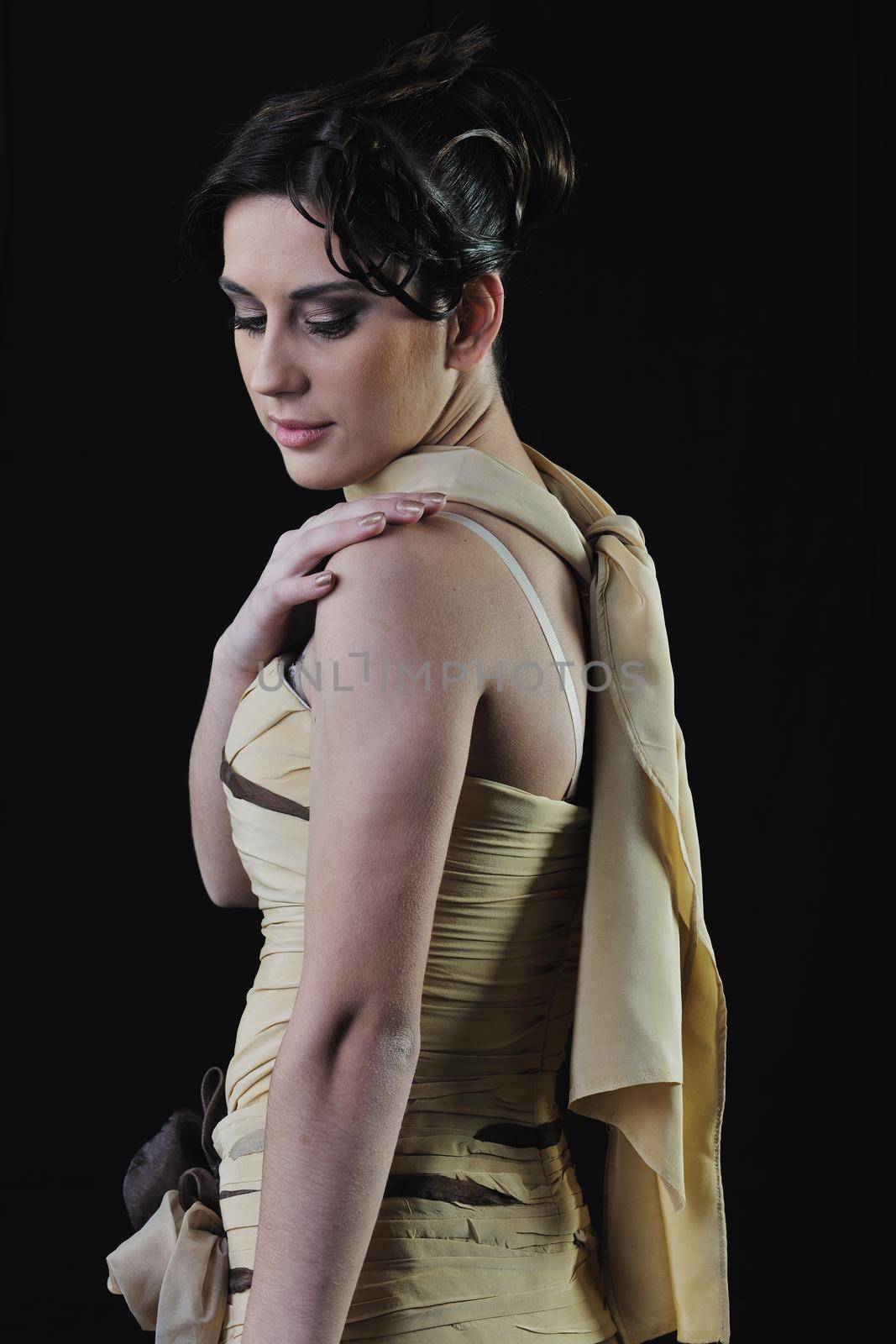  young woman in beautiful luxury dress in studio against black background in dark representing nightlife and fashion concept