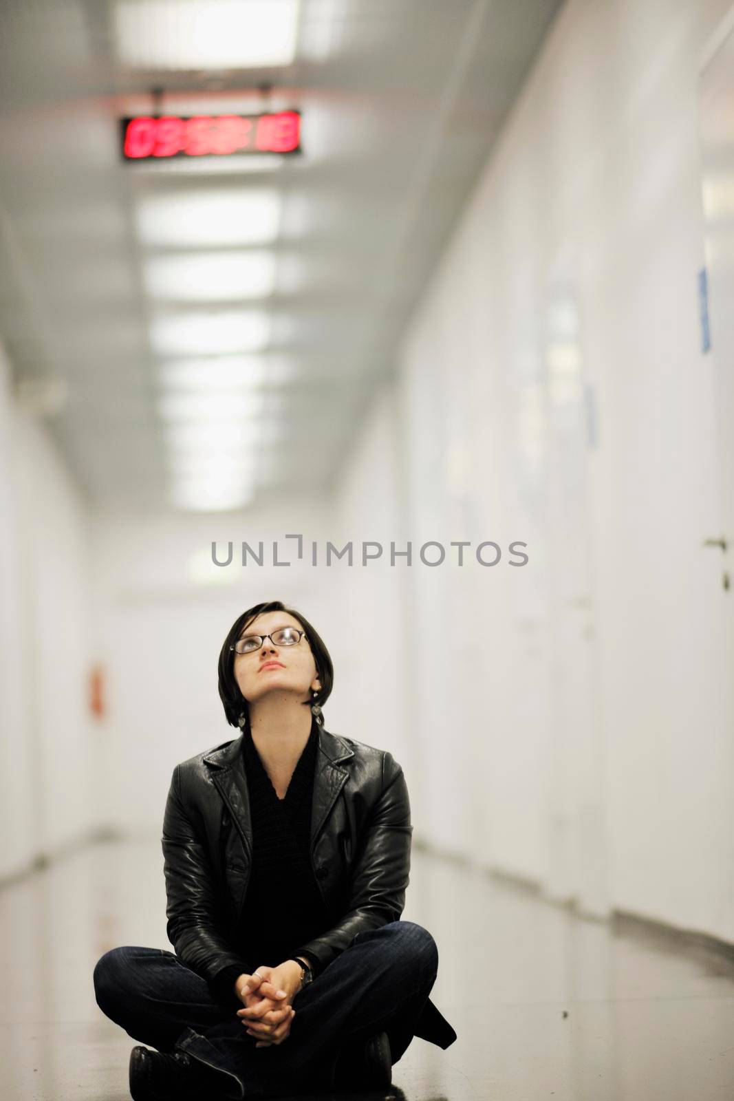 young casual woman sitting and precticing yoga indoor on abstract location