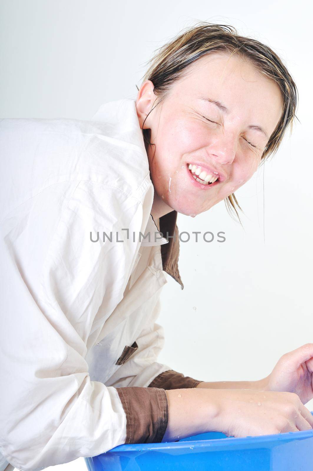 bautiful young woman wash face with clean water isolated on white in studio