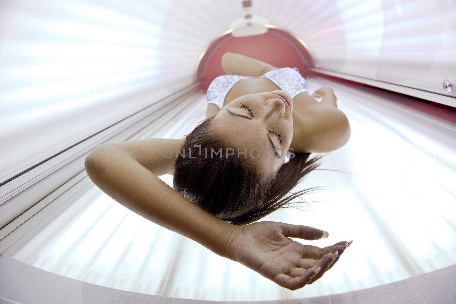 Beautiful young woman have tanning skin treatment in modern solarium