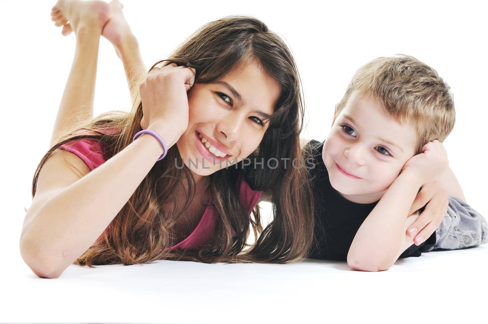 happy kids boy and girl lie on floor and play or kiss 