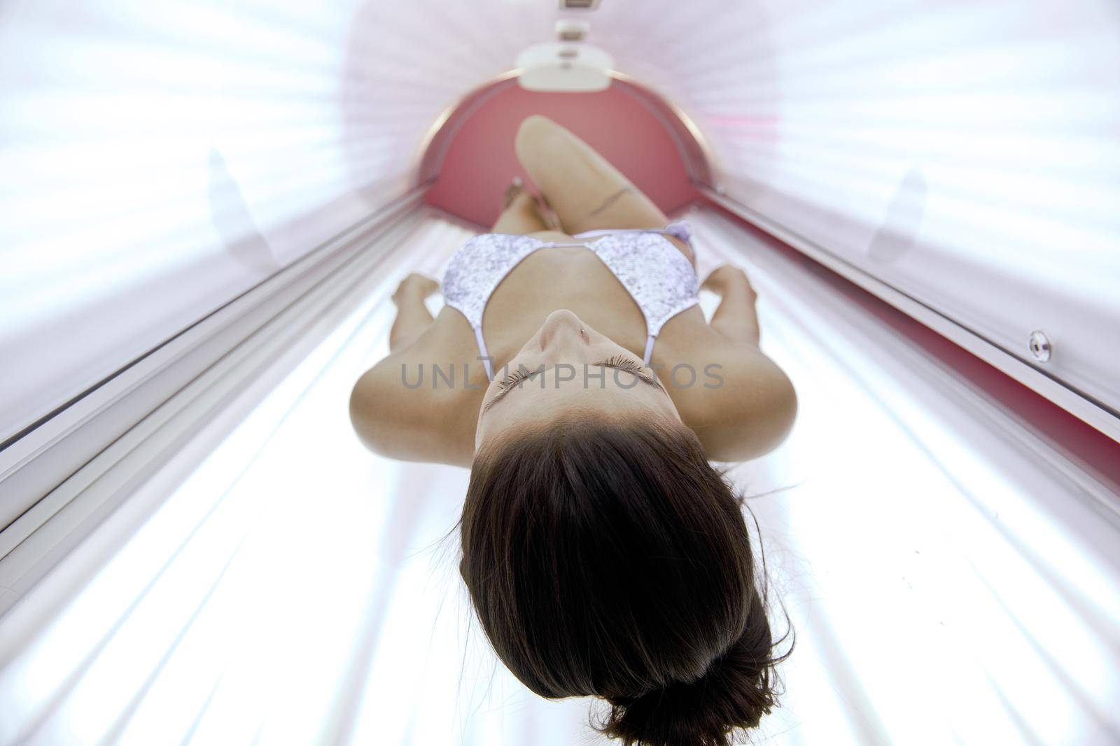 Beautiful young woman have tanning skin treatment in modern solarium