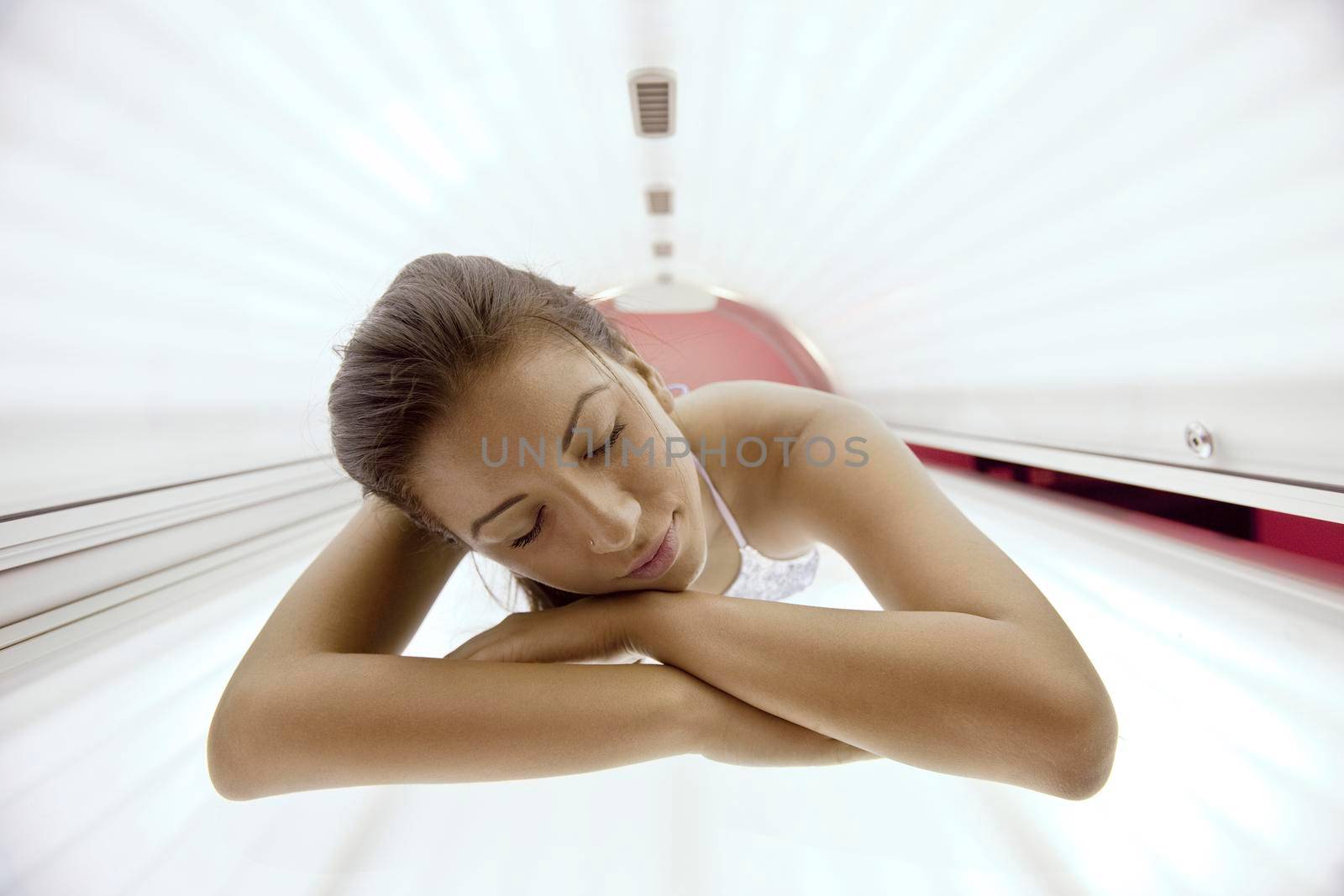 Beautiful young woman have tanning skin treatment in modern solarium