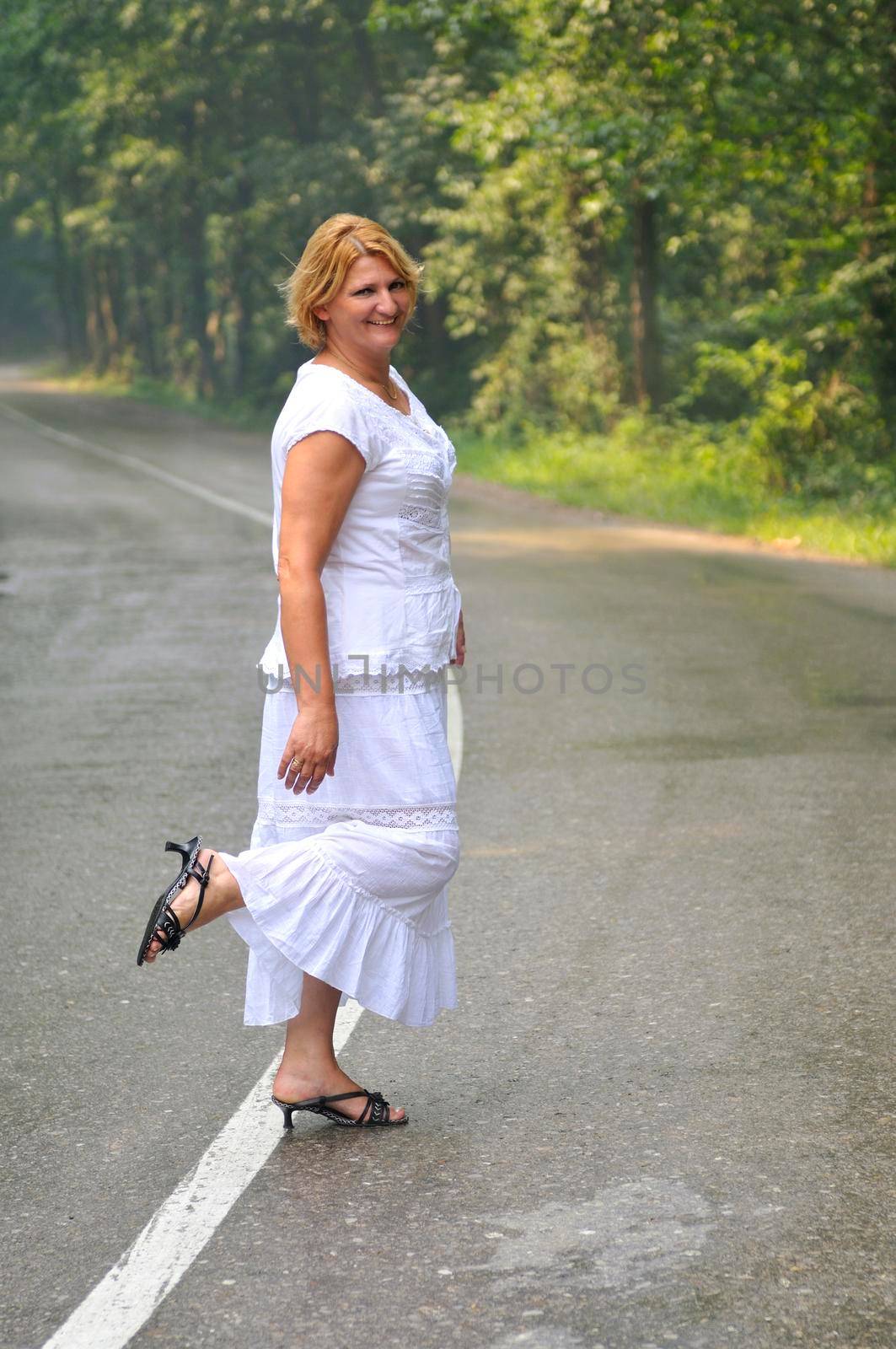 mature aged old senior woman walk and balance on road in fresh nature