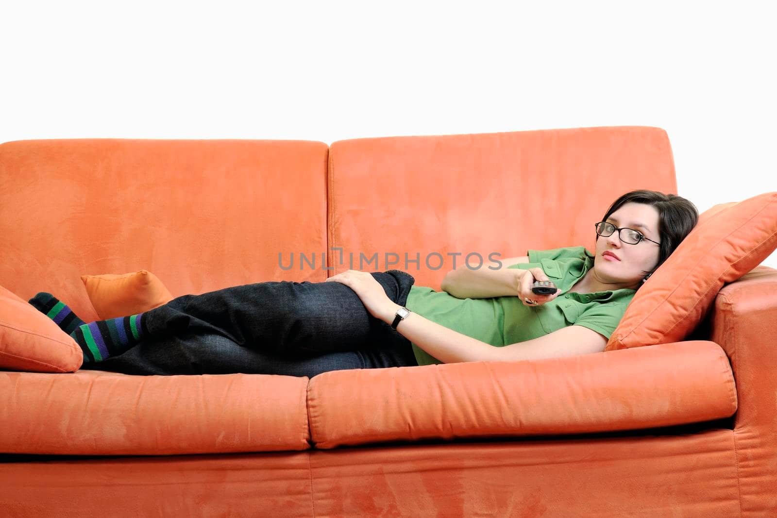 happy young woman relax on orange sofa isolated on white in studio