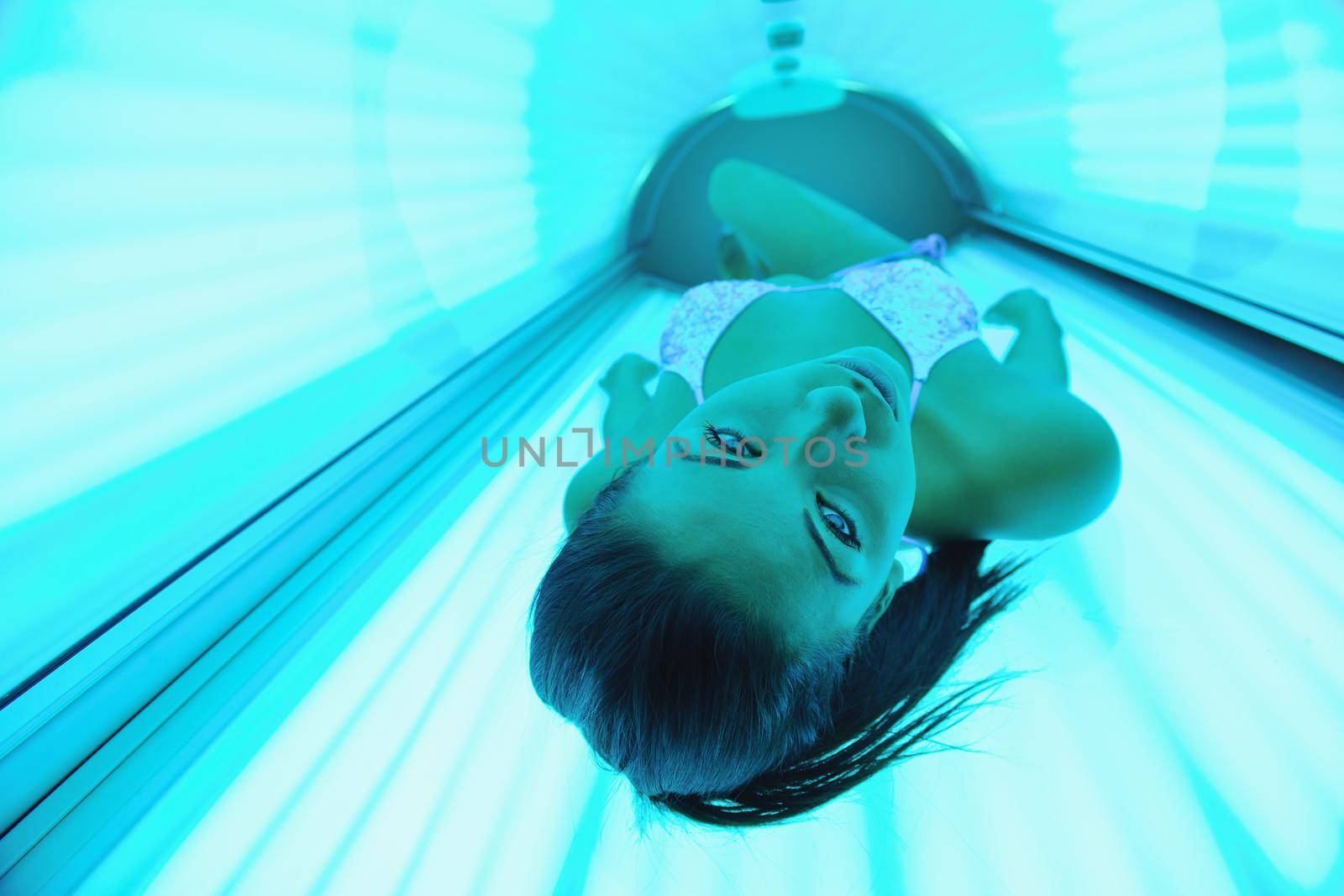 Beautiful young woman have tanning skin treatment in modern solarium