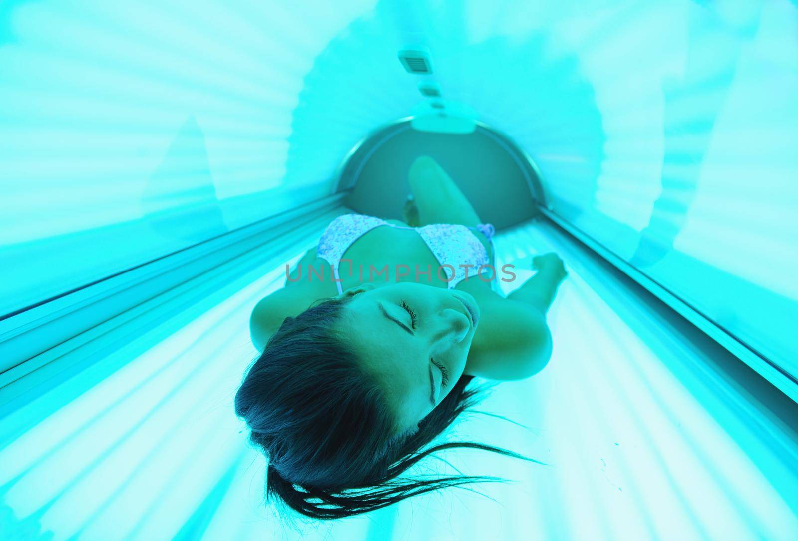 Beautiful young woman have tanning skin treatment in modern solarium