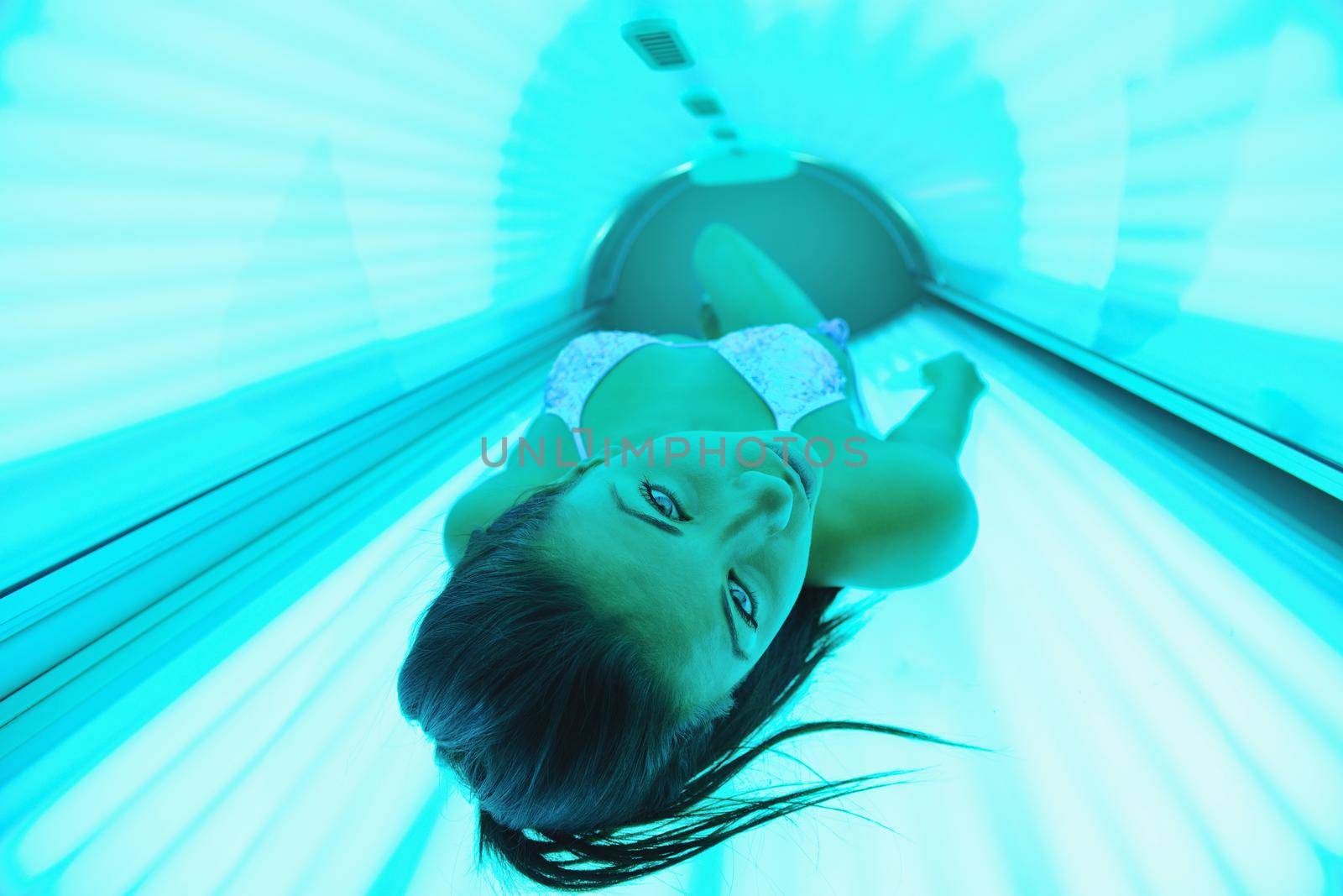 Beautiful young woman have tanning skin treatment in modern solarium