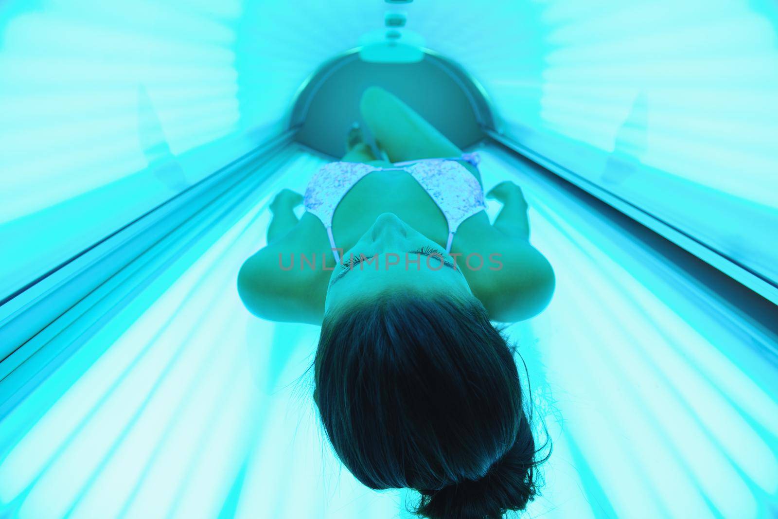 Beautiful young woman have tanning skin treatment in modern solarium