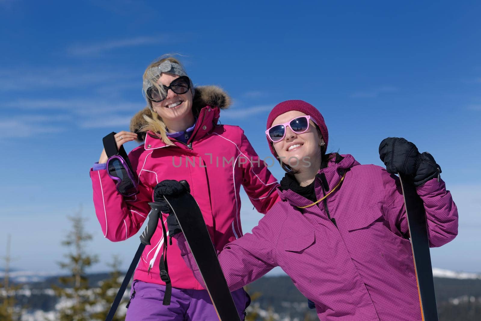 happy friends group of woman girls have fun at winter season at beautiful sunny  snow day with blue sky in background