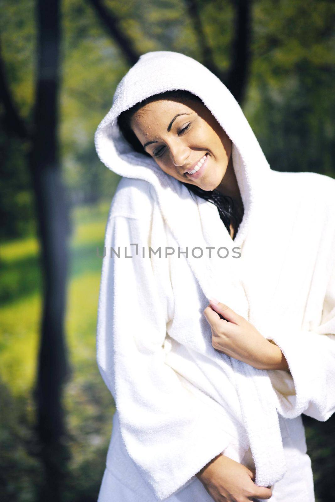 Pretty Young woman take a steam bath treatment at finish wooden sauna while wearing white towel