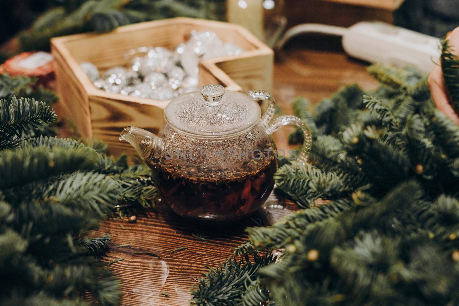 Creation of a Christmas wreath from natural fir and Christmas decorations. Master class on creating a Christmas wreath. made Decor with your own hands. Glass kettle with delicious brewed tea.