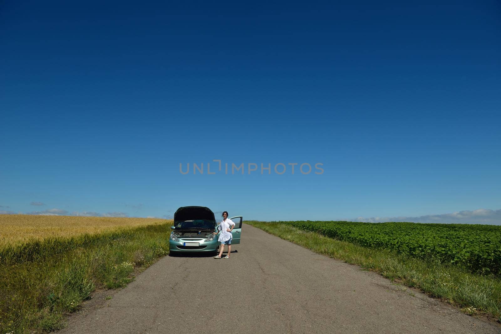 portrait of young beautiful woman with broken car outdoor