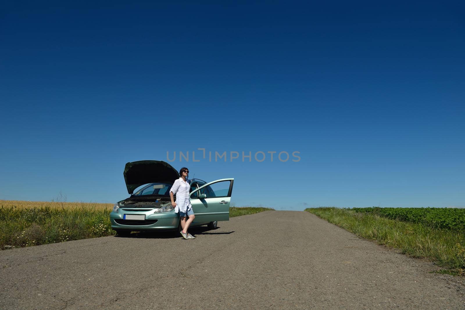 portrait of young beautiful woman with broken car outdoor