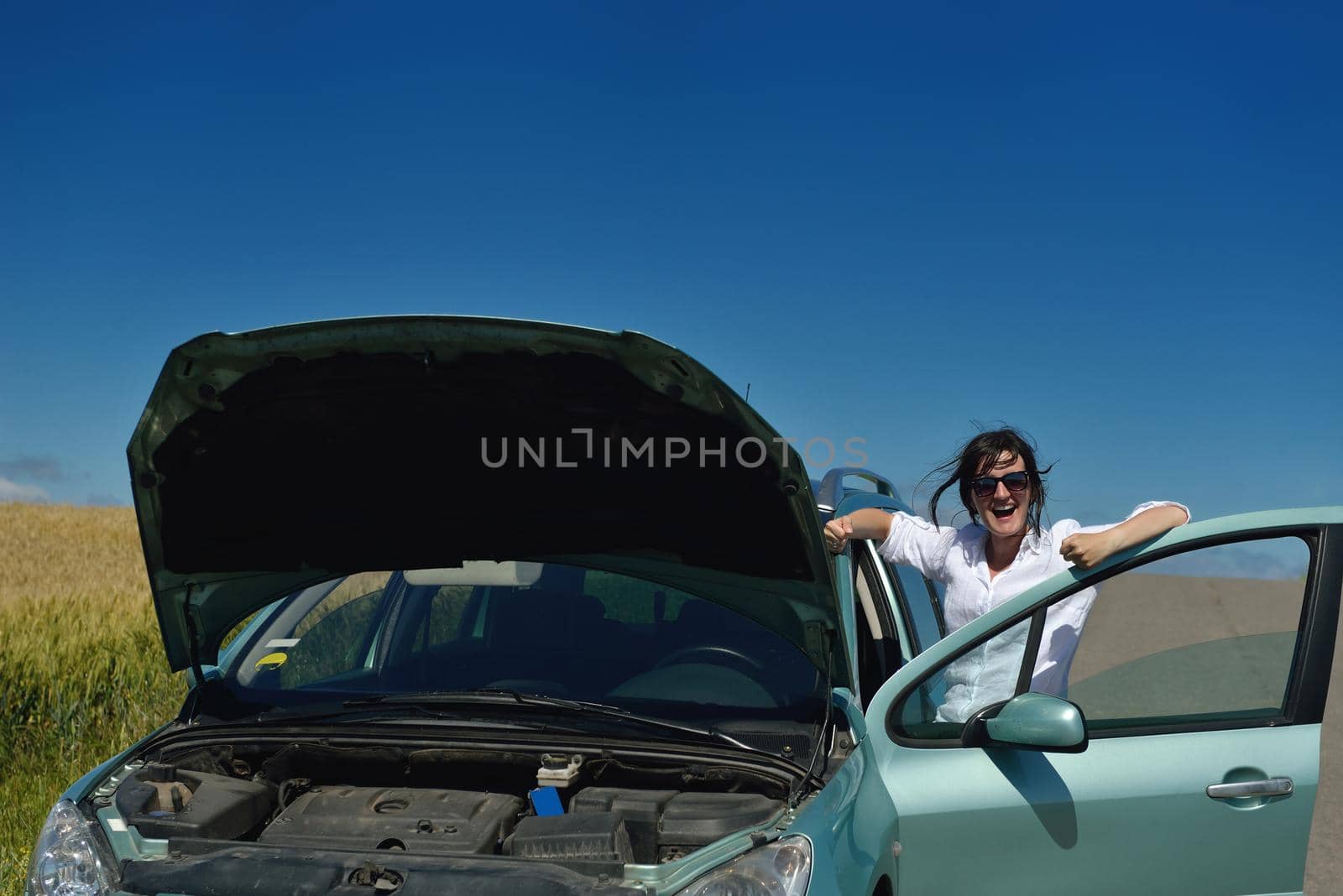 portrait of young beautiful woman with broken car outdoor