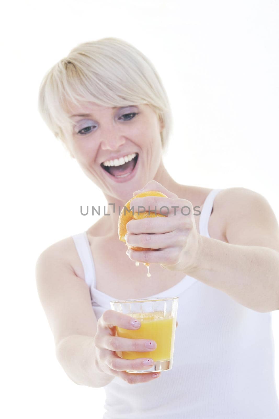 happy Young blonde woman squeeze  orange juice isolated over white background