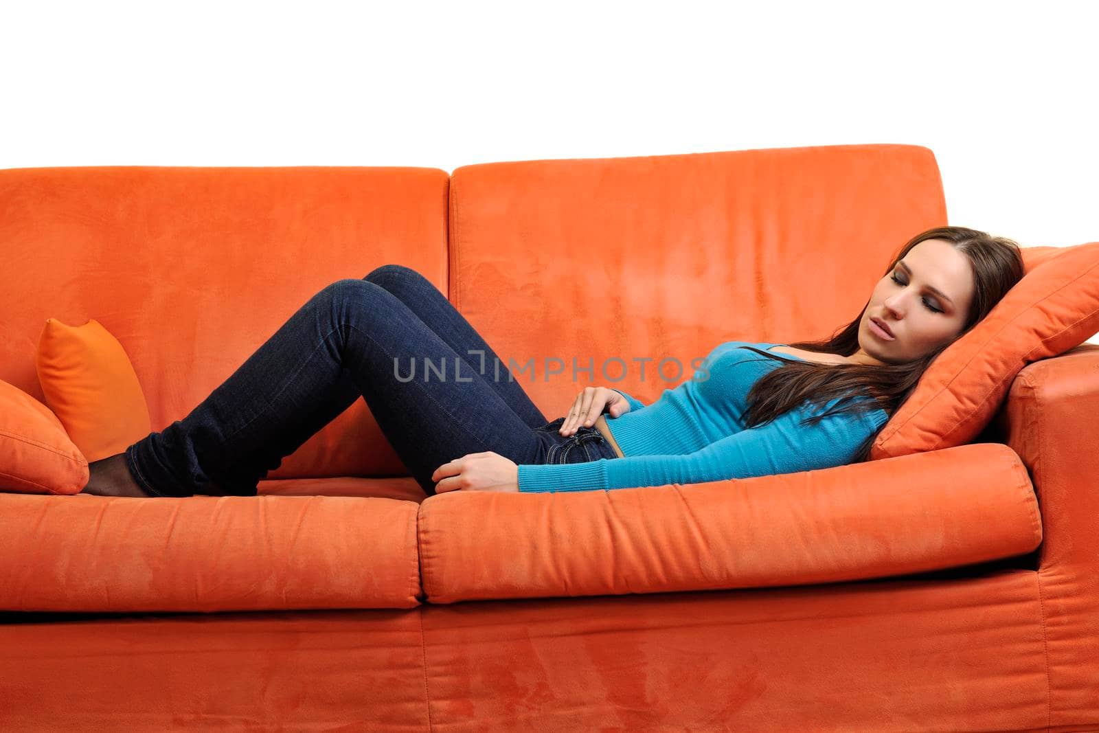 happy young woman relax on orange sofa  at home isolated on white background in studio