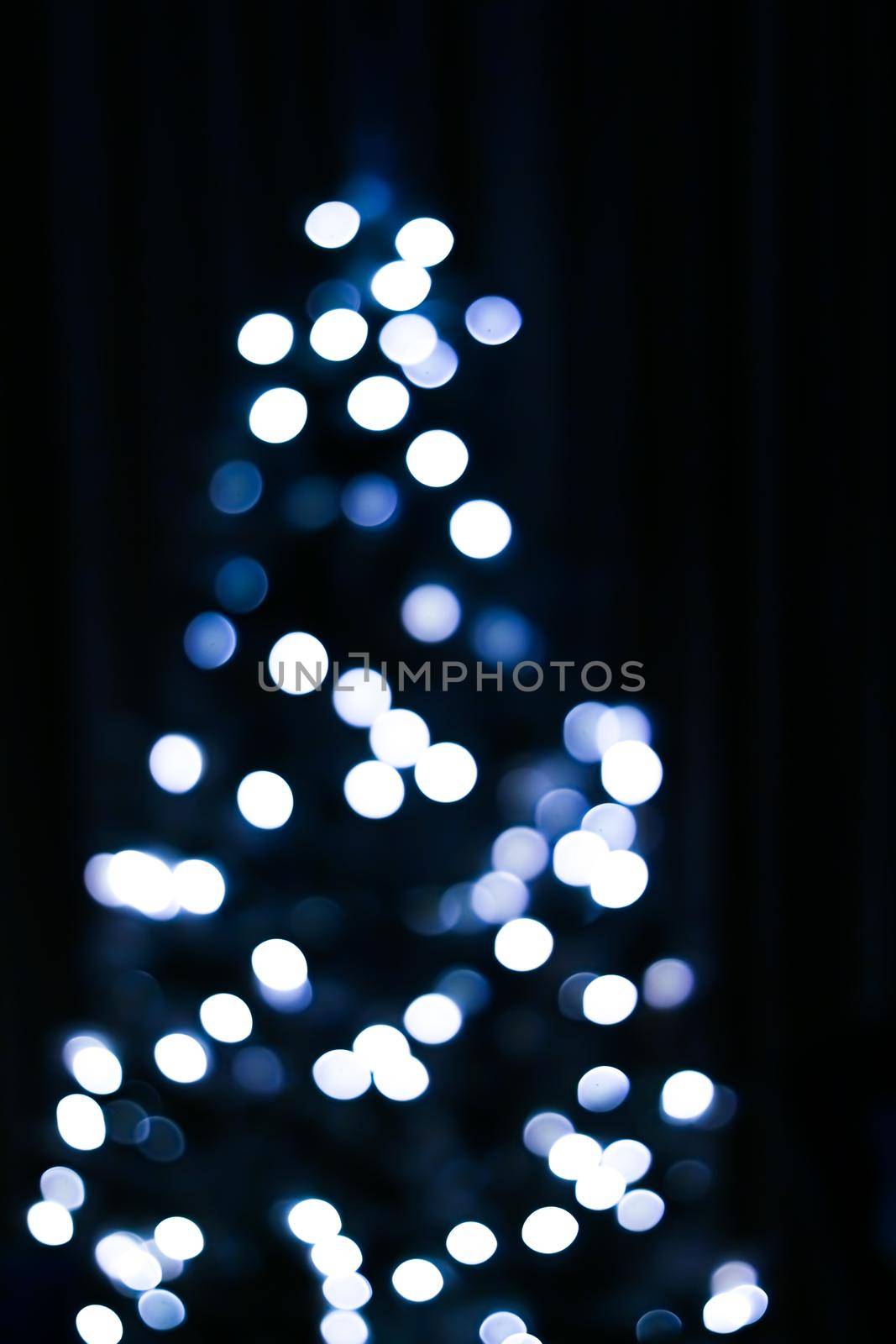 Christmas time and holiday mood concept. Blurred blue xmas tree lights as bokeh background.