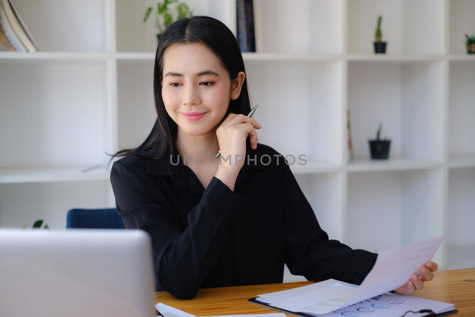 Business woman hand holding pen and budget account paperwork, account or saving money or insurance concept by itchaznong