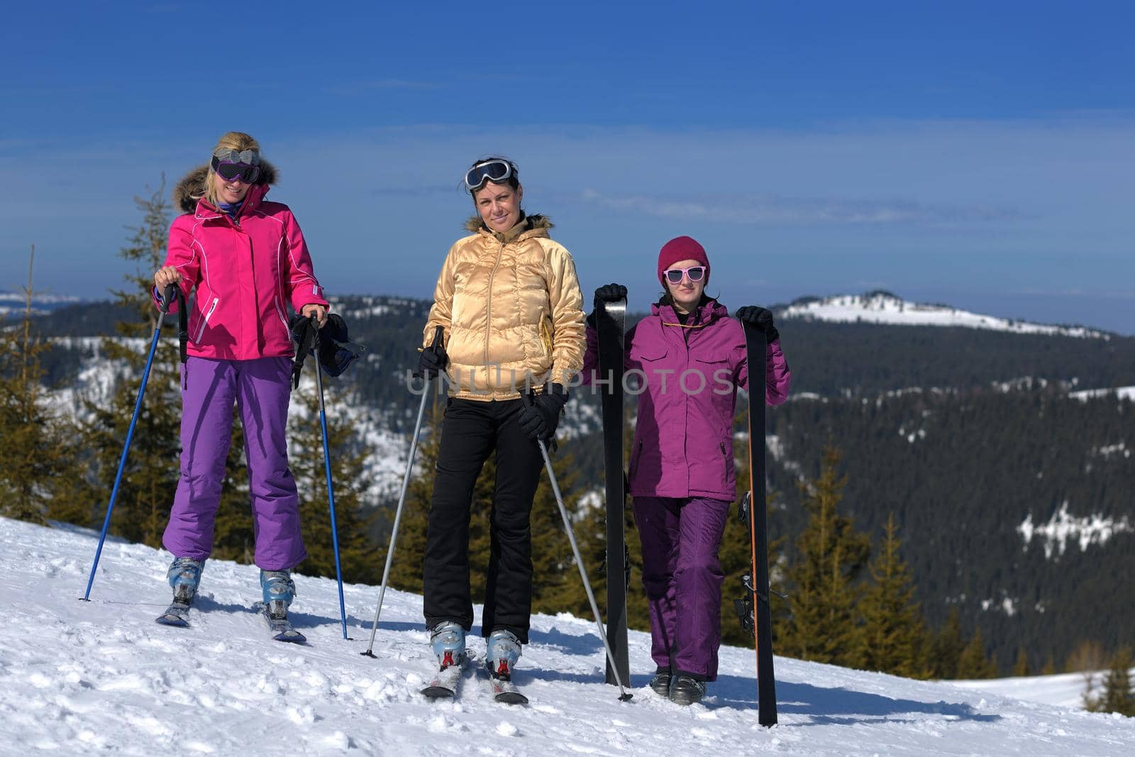 happy friends group of woman girls have fun at winter season at beautiful sunny  snow day with blue sky in background