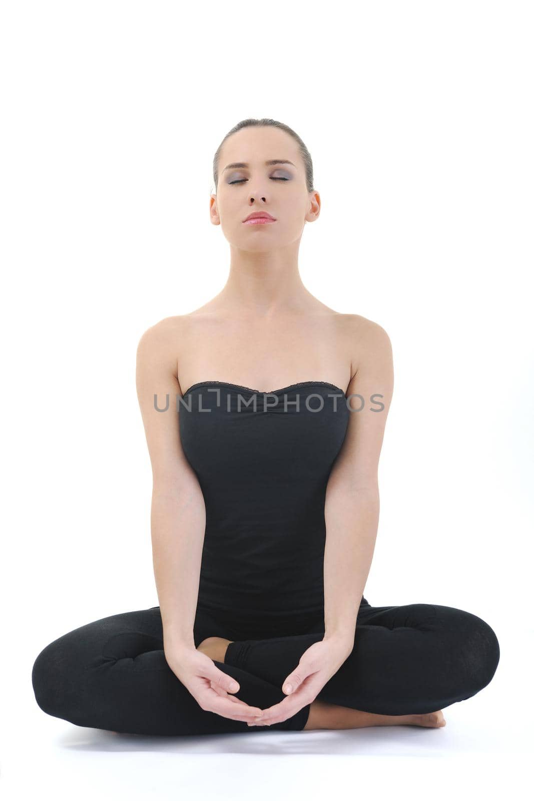 young brunette woman in black sport wear meditating yoga in lotus postition isolated on white background