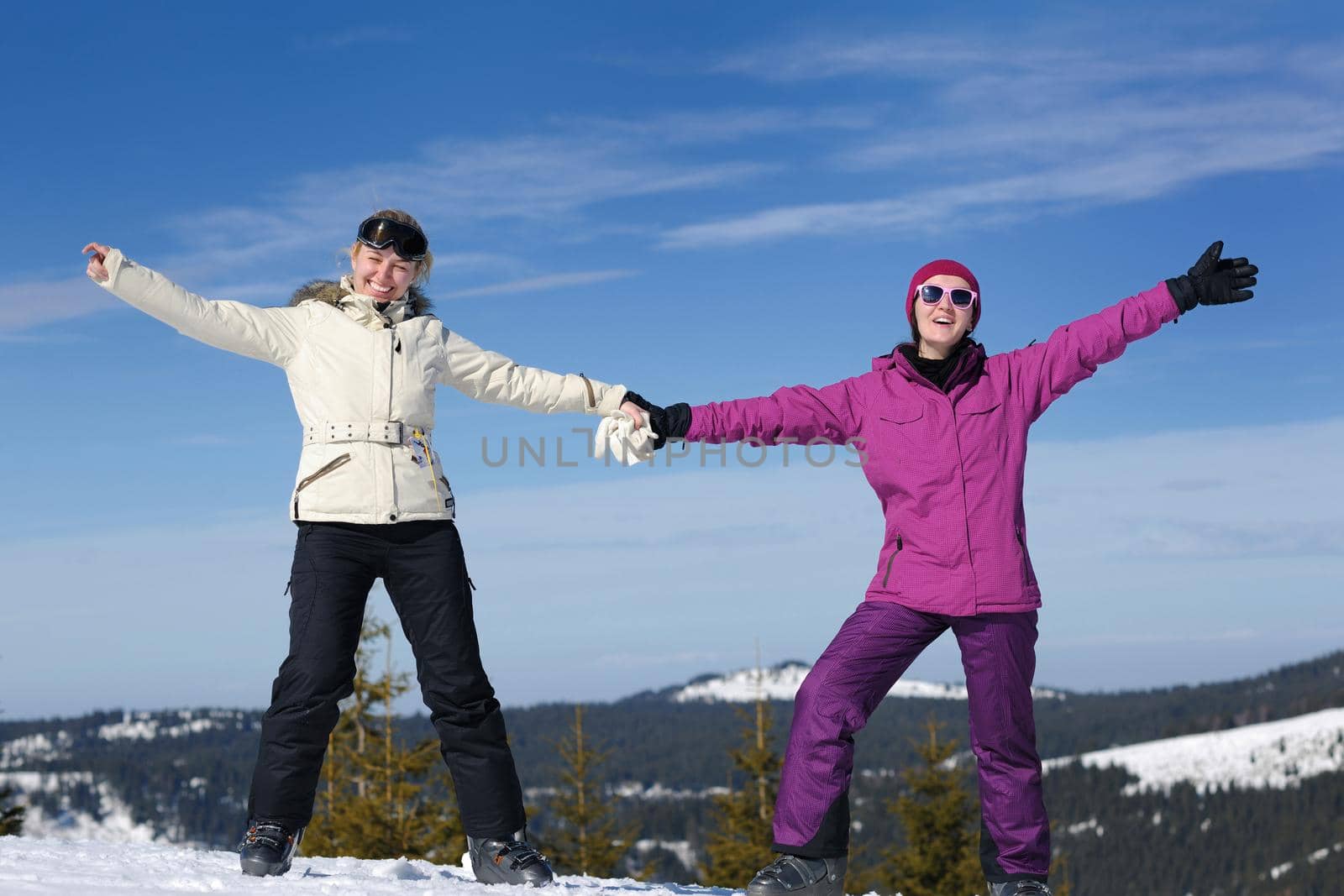 happy friends group of woman girls have fun at winter season at beautiful sunny  snow day with blue sky in background