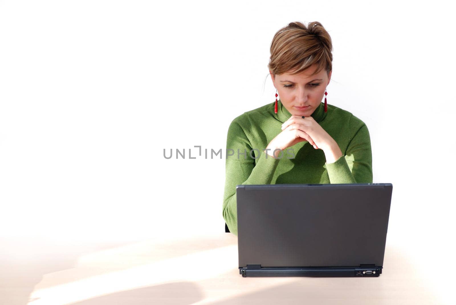 businesswoman in green working on laptop