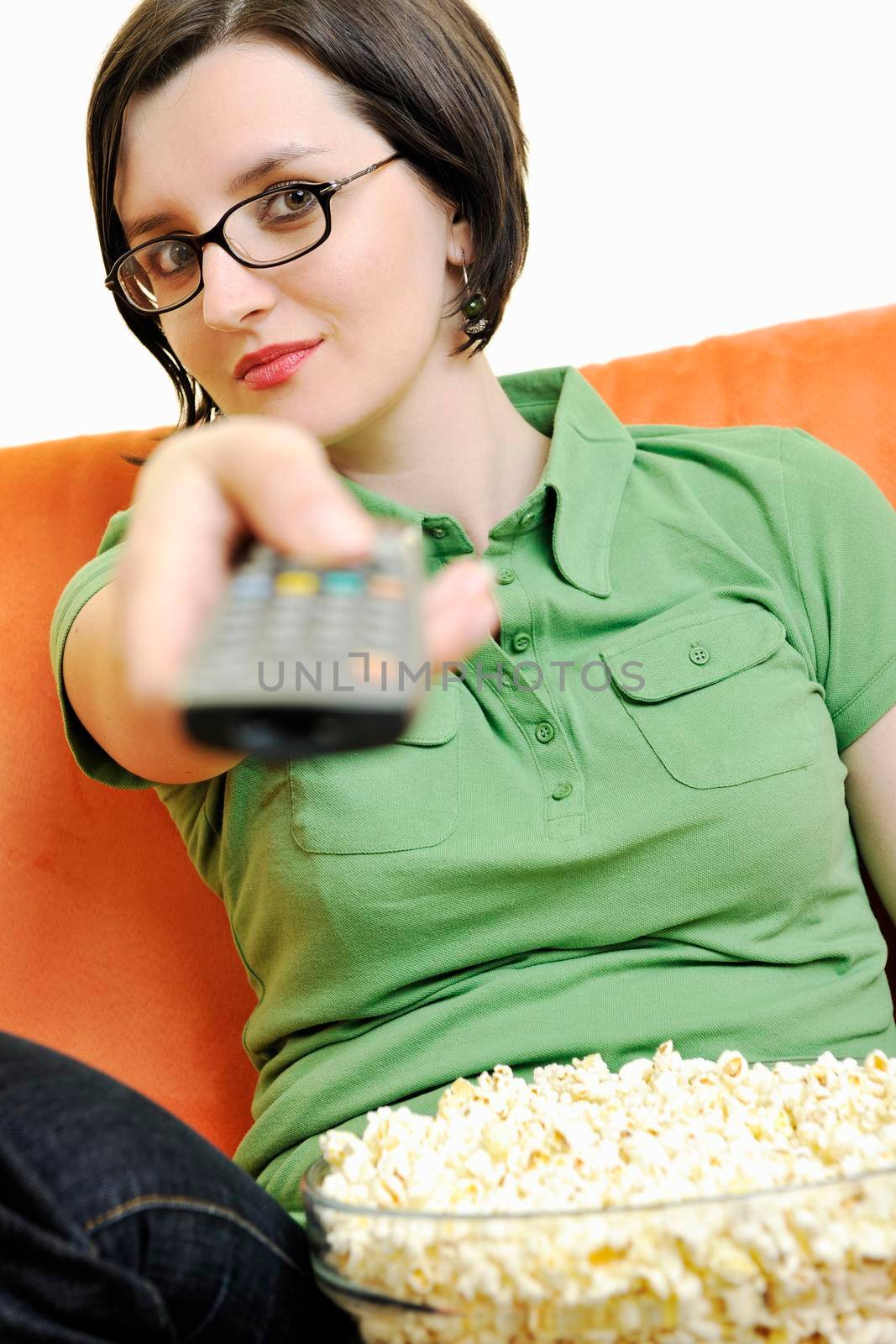 young woman eat popcorn on orange sofa by dotshock