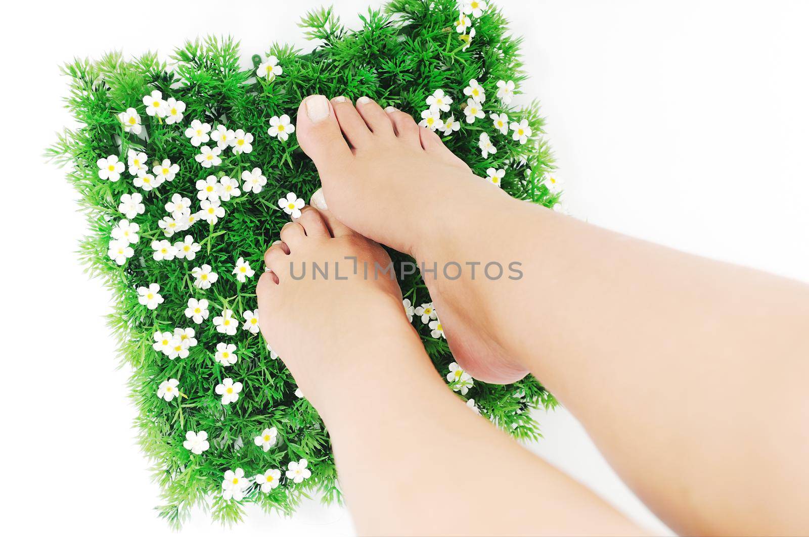 woman legs walking on small peace of green grass isolated on white representing last oasis concept