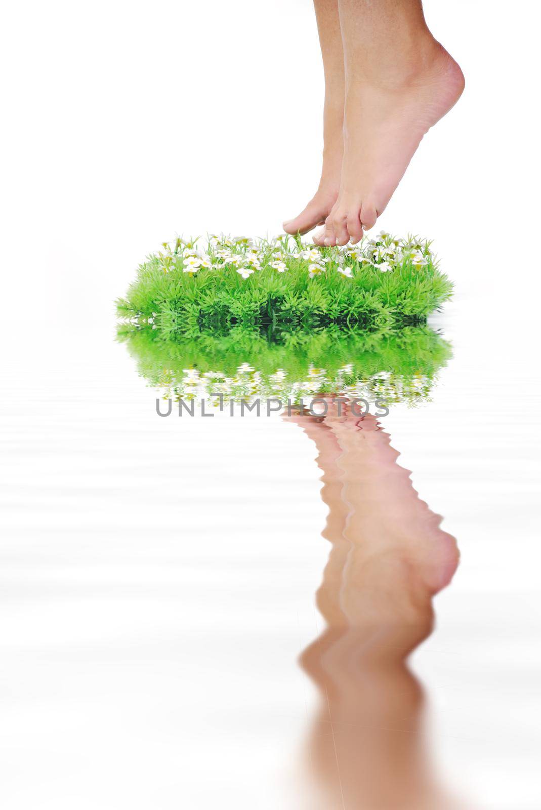 woman legs walking on small peace of green grass isolated on white representing last oasis concept