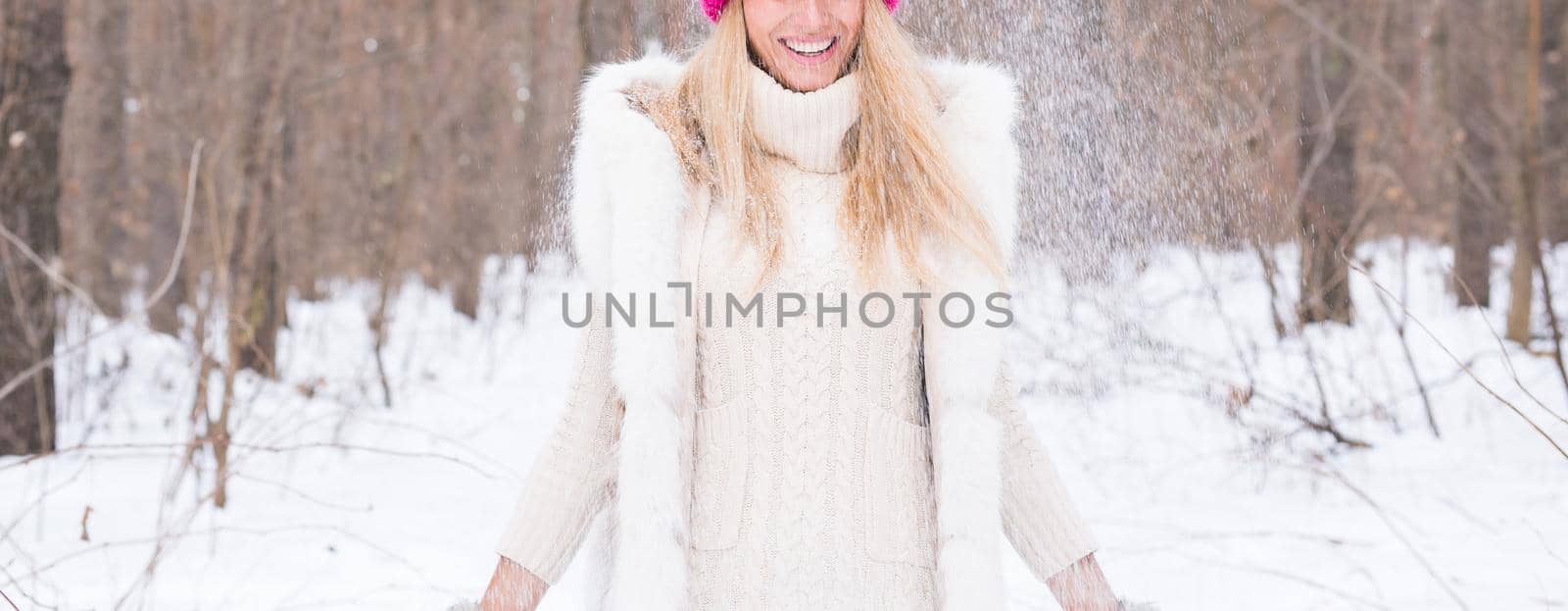 Fun, winter and people concept - Attractive woman dressed in white coat throwing snow