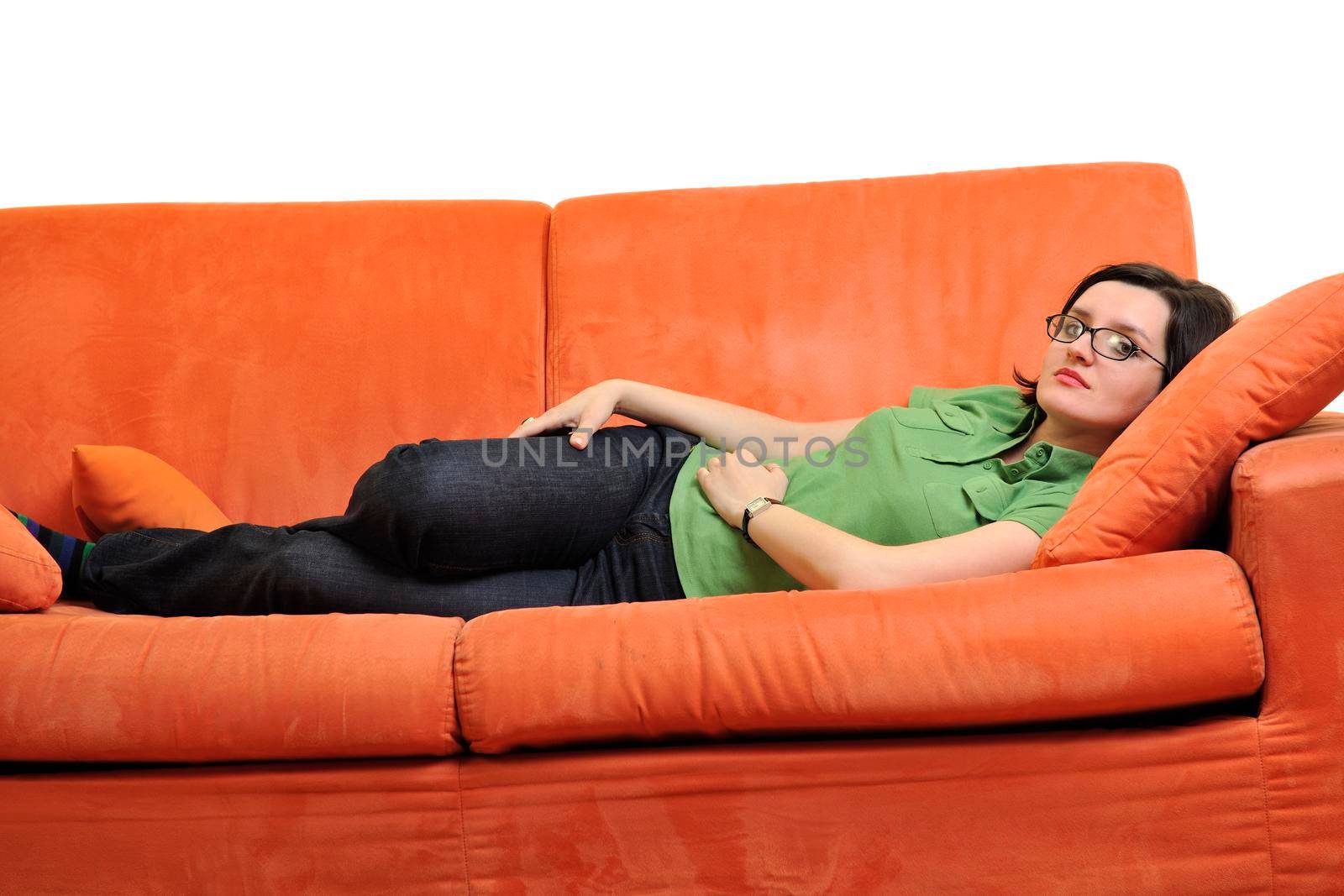 happy young woman relax on orange sofa  at home isolated on white background in studio