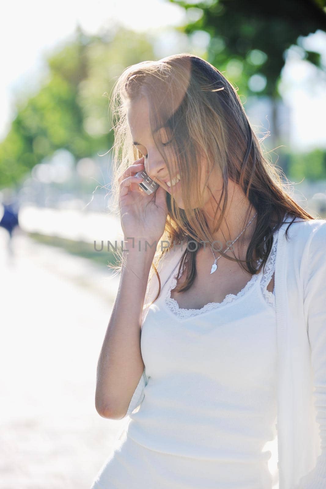 beautiful fit young woman talk by cellphone in city at street on sunny day