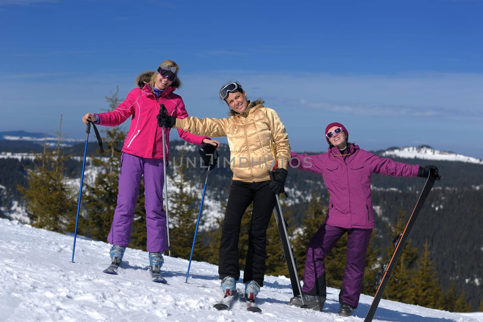 happy friends group of woman girls have fun at winter season at beautiful sunny  snow day with blue sky in background